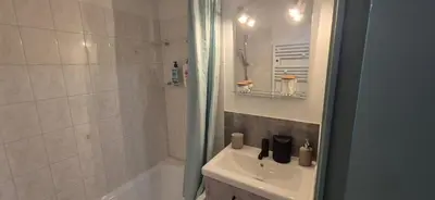 a white bathroom with a sink and a shower at Appartement O'Contamines in Les Contamines-Montjoie