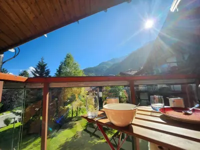 a table on a balcony with a view of the mountains at Appartement O'Contamines in Les Contamines-Montjoie