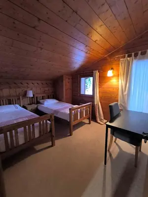a room with two beds and a table in a cabin at Chalet Cannon- Mountain Getaway in Les Contamines-Montjoie