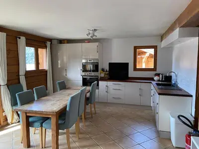 a kitchen with a wooden table and chairs in a kitchen at Chalet Cannon- Mountain Getaway in Les Contamines-Montjoie