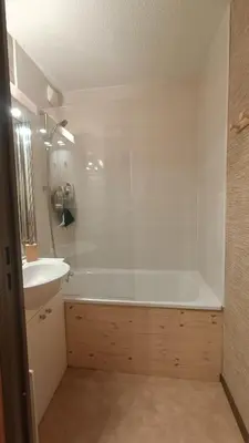 a bathroom with a white tub and a sink at Appartement pied des pistes - Samoëns 1600 in Samoëns