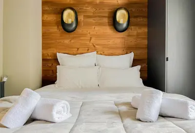 a bedroom with a bed with white towels on it at Masai Megeve in Megève