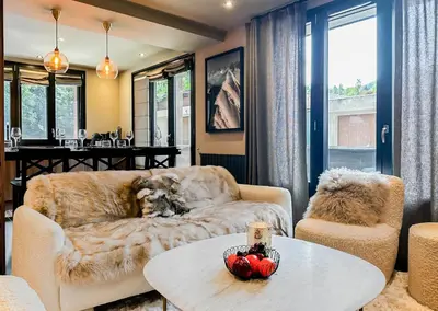 a living room with a couch and a table at Masai Megeve in Megève
