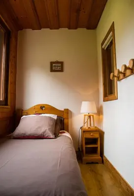 a bedroom with a bed and a lamp on a table at Gite Balnéo La Pomme de Pin in Sixt