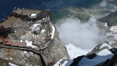 a building on the side of a mountain with snow at Apartment Bonatti 201 in Chamonix-Mont-Blanc