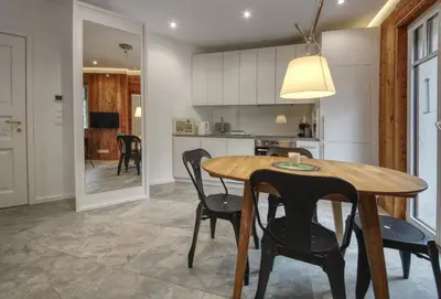 a kitchen and dining room with a wooden table and chairs at Apartment Bonatti 201 in Chamonix-Mont-Blanc