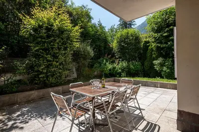 a wooden table with chairs and a bottle of wine at Apartment Villa Vallet 1, Alpes Travel, Chamonix Old Town, Sleeps 6 in Chamonix-Mont-Blanc