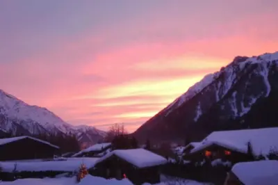 a sunset over a mountain range with snow covered buildings at Mazot le Petit Drus in Chamonix-Mont-Blanc