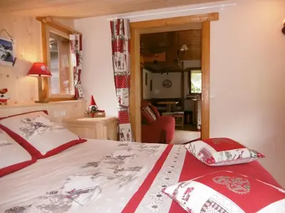 a bedroom with a bed with red and white sheets at Mazot le Petit Drus in Chamonix-Mont-Blanc