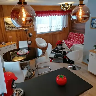 a kitchen and living room with a table and chairs at Le p'tit Rubis in Chamonix-Mont-Blanc