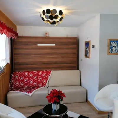 a living room with a white couch with red pillows at Le p'tit Rubis in Chamonix-Mont-Blanc