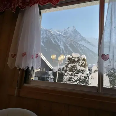 a window with a view of a snow covered mountain at Le p'tit Rubis in Chamonix-Mont-Blanc