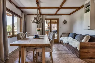 a dining room with a table and a couch at Panorama du Mont-Blanc- Spacious and ideally located 1 bedroom apartment in Chamonix-Mont-Blanc