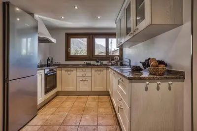 a kitchen with white cabinets and stainless steel appliances at Panorama du Mont-Blanc- Spacious and ideally located 1 bedroom apartment in Chamonix-Mont-Blanc