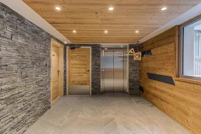 a hallway with a door and a brick wall at White Pearl A05 Modern apartment Chamonix Alpes Travel Sleeps 4 to 6 in Chamonix-Mont-Blanc