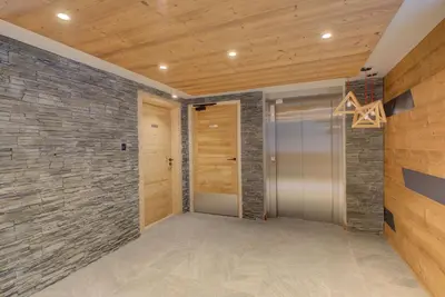 a hallway with a stone wall and a door at White Pearl A05 Modern apartment Chamonix Alpes Travel Sleeps 4 to 6 in Chamonix-Mont-Blanc