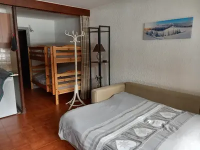 a bedroom with a bed and a wooden floor at SKI AUX PIEDS et PIEDS DANS L'EAU in Les Contamines-Montjoie