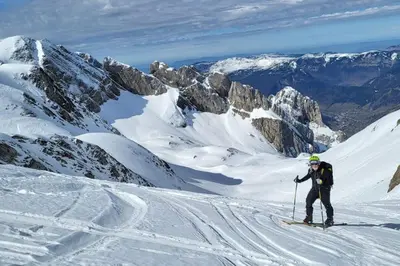 a man is skiing down a snow covered mountain at SKI AUX PIEDS et PIEDS DANS L'EAU in Les Contamines-Montjoie