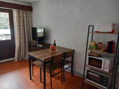 a room with a table and a television and a table and chairs at SKI AUX PIEDS et PIEDS DANS L'EAU in Les Contamines-Montjoie