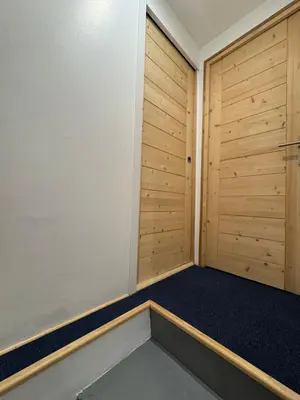 a room with wooden doors and a blue carpet at Le Petit Cham in Chamonix-Mont-Blanc