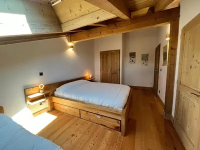 a bedroom with a bed and a wooden floor at Magnifique duplex 3 chambres près du Grand Massif, wifi et garage - FR-1-624-136 in Samoëns