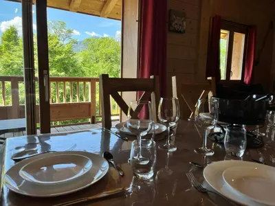 a table with plates and wine glasses on a porch at Magnifique duplex 3 chambres près du Grand Massif, wifi et garage - FR-1-624-136 in Samoëns