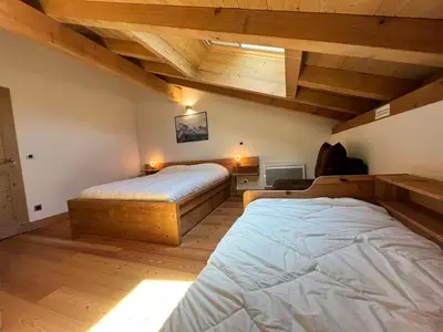 two beds in a room with wooden ceilings at Magnifique duplex 3 chambres près du Grand Massif, wifi et garage - FR-1-624-136 in Samoëns