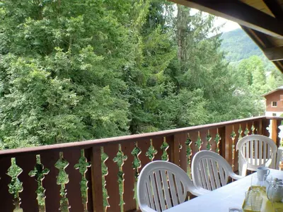 a table and chairs on a balcony with trees at Appartement T4 pour 8 pers, animaux admis, parking - FR-1-629-131 in Samoëns