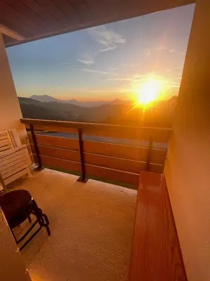 a balcony with a view of the sunset at Samoëns 1600 studio au pied des pistes in Samoëns