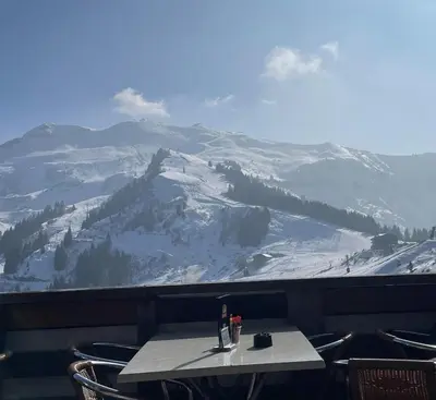 a table with a glass of wine on top of a mountain at Samoëns 1600 studio au pied des pistes in Samoëns