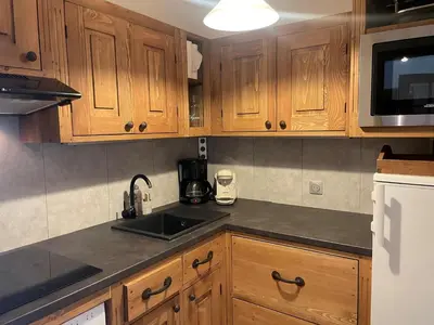 a kitchen with wooden cabinets and a sink at Appartement avec balcon, parking et animaux acceptés à Chamonix - FR-1-343-245 in Chamonix-Mont-Blanc