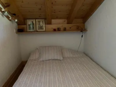 a bed in a small room with a wooden ceiling at Apartment Village des Oursons Chalet A4 by Interhome in Chamonix-Mont-Blanc