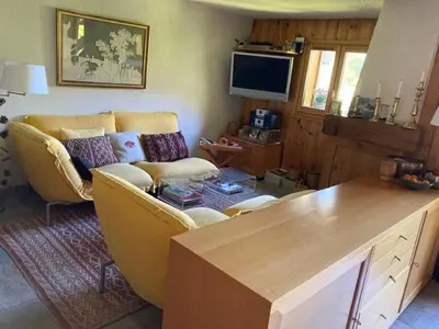 a living room with a couch and a table at Apartment Village des Oursons Chalet A4 by Interhome in Chamonix-Mont-Blanc
