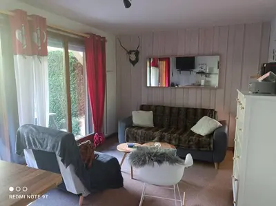 a living room with a couch and a table at Appartement en rez de jardin vue montagne in Les Contamines-Montjoie