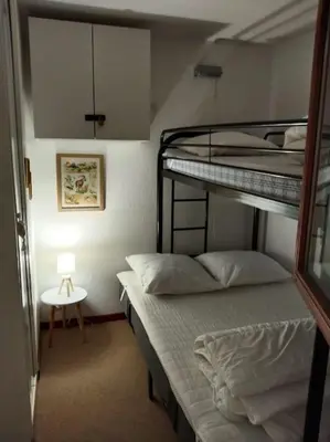 two bunk beds in a small room with a lamp at Appartement en rez de jardin vue montagne in Les Contamines-Montjoie
