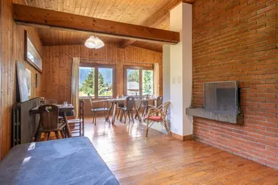 a living room with a brick wall and a table and chairs at Rustic chalet with garden in Chamonix in Chamonix-Mont-Blanc