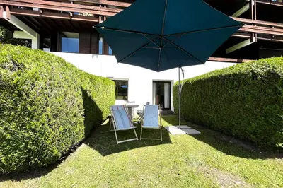 two chairs and an umbrella in a yard at Nid d'Arbois in Megève