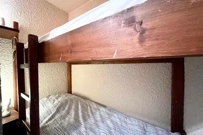 a bunk bed in a room with a wooden headboard at Nid d'Arbois in Megève