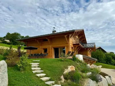 a cabin in the snow with a view of the mountains at Chalet du Feug in Combloux