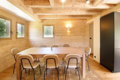 a dining room with a wooden table and chairs at Chalet Béchar Le Magnifique- Garden - Sauna & Jacuzzi in Les Houches