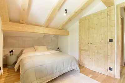 a bedroom with a bed and a large wooden door at Chalet Béchar Le Magnifique- Garden - Sauna & Jacuzzi in Les Houches
