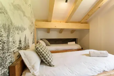 two twin beds in a room with wooden ceilings at Chalet Béchar Le Magnifique- Garden - Sauna & Jacuzzi in Les Houches