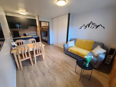 a living room with a couch and a table at Studio cosy de 23 m2 à la montagne in Samoëns