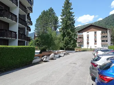 a parking lot in a apartment complex with cars parked at Studio cosy de 23 m2 à la montagne in Samoëns