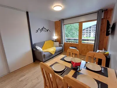 a living room with a table and chairs and a couch at Studio cosy de 23 m2 à la montagne in Samoëns
