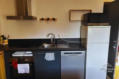 a kitchen with a sink and a white refrigerator at Appartements 2 pièces vue Mont-Joly à 2 pas Tramway Mont-Blanc in Saint-Gervais-les-Bains
