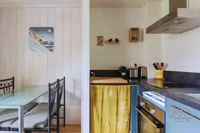 a kitchen with a counter top and a table with a tableablish at Appartements 2 pièces vue Mont-Joly à 2 pas Tramway Mont-Blanc in Saint-Gervais-les-Bains