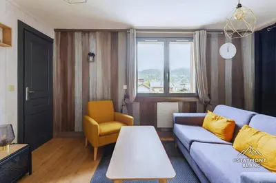 a living room with a blue couch and a yellow chair at Appartements 2 pièces vue Mont-Joly à 2 pas Tramway Mont-Blanc in Saint-Gervais-les-Bains