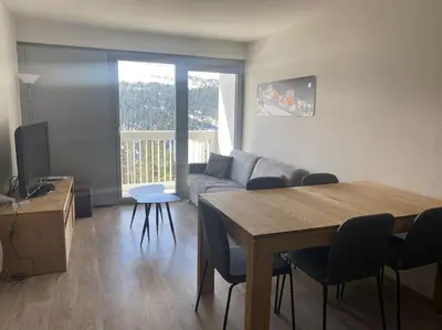 a living room with a couch and a table and chairs at Appart 6 personnes, balcon plein sud in Flaine