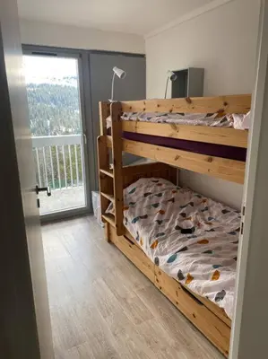 a bedroom with a bunk bed and a large window at Appart 6 personnes, balcon plein sud in Flaine